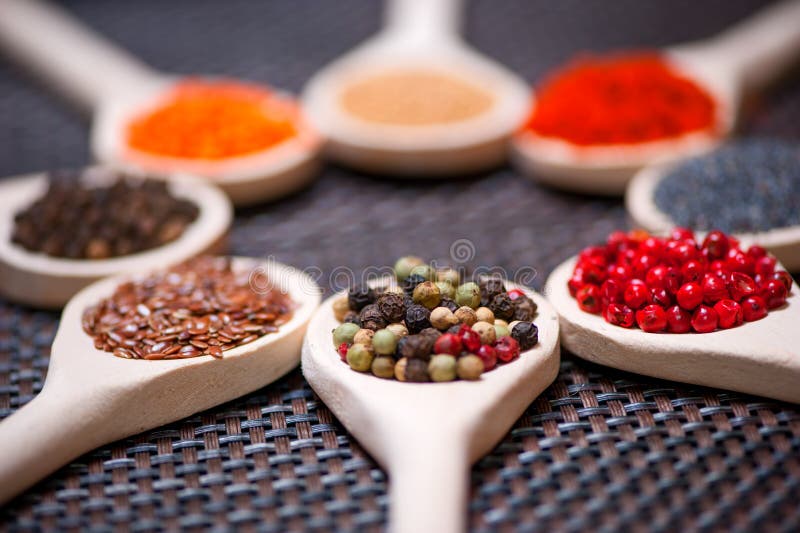 Various kind of spices on wooden spoon - detail of black pepper