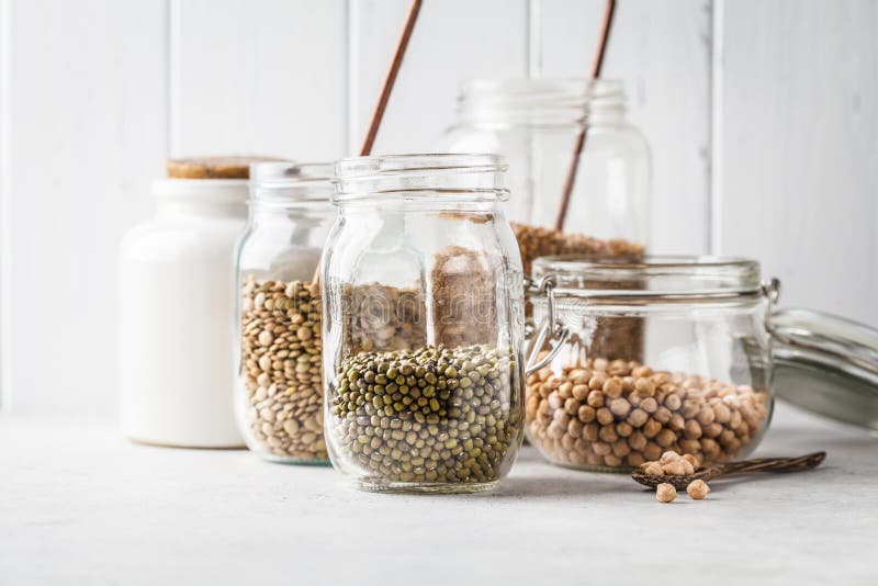 Various legumes: beans, chickpeas, buckwheat, lentils in glass jars on a white background stock photos Various legumes: beans, chickpeas, buckwheat, lentils in glass jars on a white background stock photos