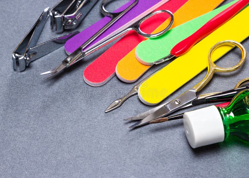 Various manicure tools on gray textured background stock photography