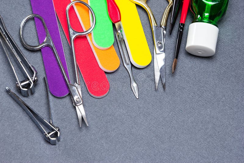 Various manicure tools on gray textured background stock images