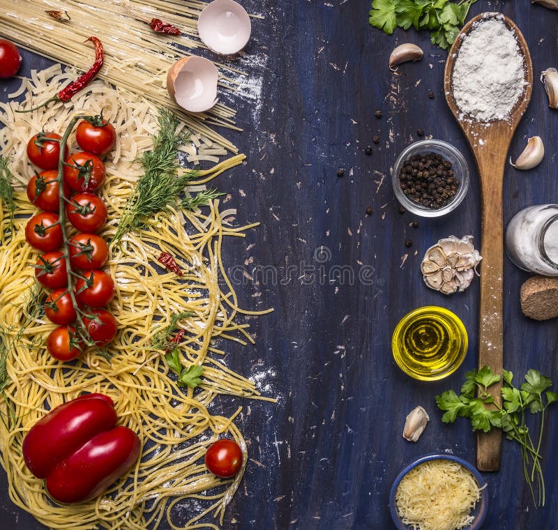 Various raw pasta with vegetables and spices, flour and wooden spoon frame with text area wooden rustic background top view stock photography Various raw pasta with vegetables and spices, flour and wooden spoon frame with text area wooden rustic background top view stock photography