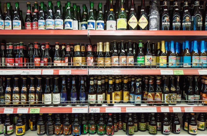 Variété de bières ouvrées belges sur l'affichage d'étagère de magasin photos stock Variété de bières ouvrées belges sur l'affichage d'étagère de magasin photos stock
