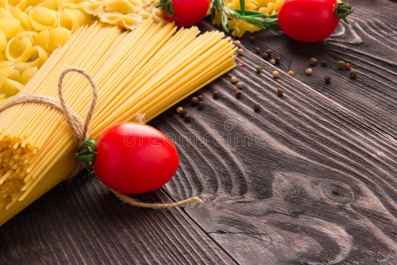 Variété de sortes et formes de macaronis secs avec les tomates et le romarin Nourriture crue ou texture de macaronis italiens : p