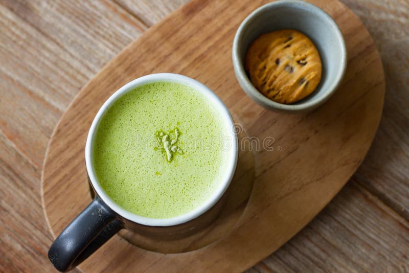 Varm bakgrund för trä för Greentea matchalatte arkivbilder