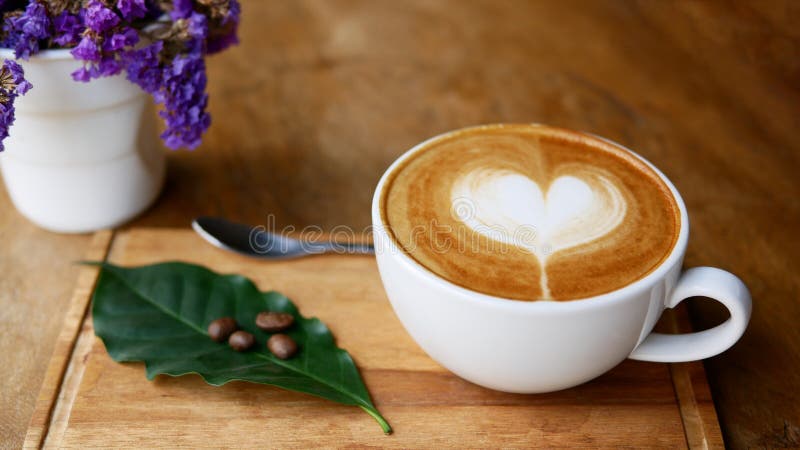 Varm form för hjärta för konst för kaffecappuccinolatte i keramisk kopp på den wood plattan royaltyfri fotografi