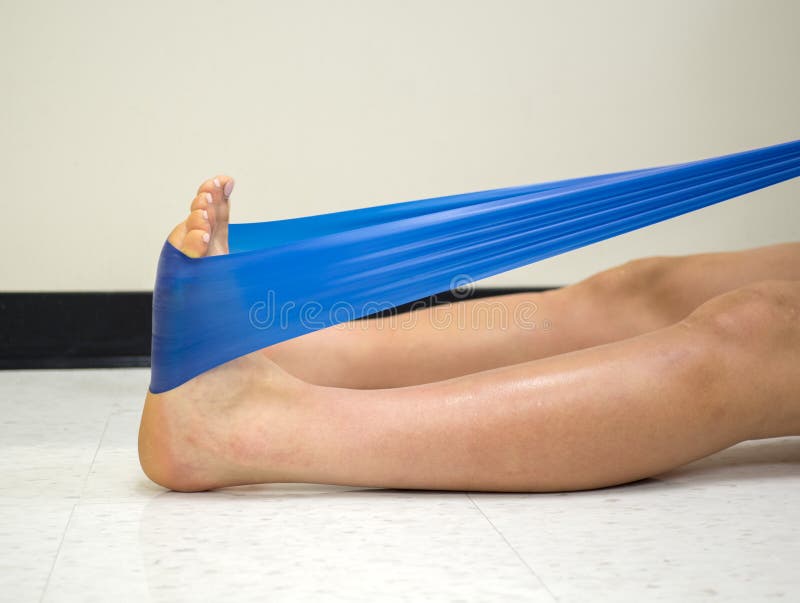 Varsity athlete using a theraband exercise band to strengthen her ankle