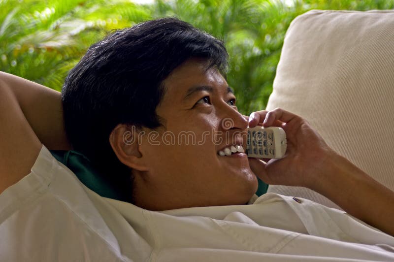 Varón asiático relajado en el teléfono con un amigo