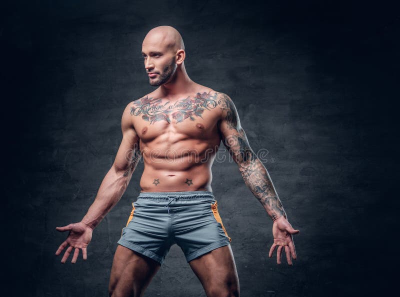 Varón muscular descamisado principal afeitado con el cuerpo tatuado imágenes de archivo libres de regalías Varón muscular descamisado principal afeitado con el cuerpo tatuado imágenes de archivo libres de regalías