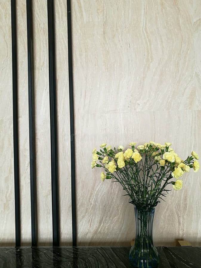 Vase de fleur jaune d'oeillet dans le côté droit de la barre de marbre dans le lobby d'hôtel avec le fond de tache floue, décorat photos libres de droits Vase de fleur jaune d'oeillet dans le côté droit de la barre de marbre dans le lobby d'hôtel avec le fond de tache floue, décorat photos libres de droits
