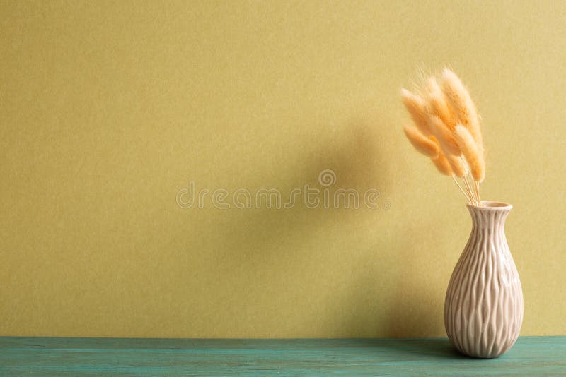 Vase of pink hares tail grass Lagurus ovatus dry flowers on wooden table