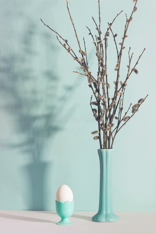 Vase with a willow and single white egg on the table; minimal Easter composition, background with copy space stock image