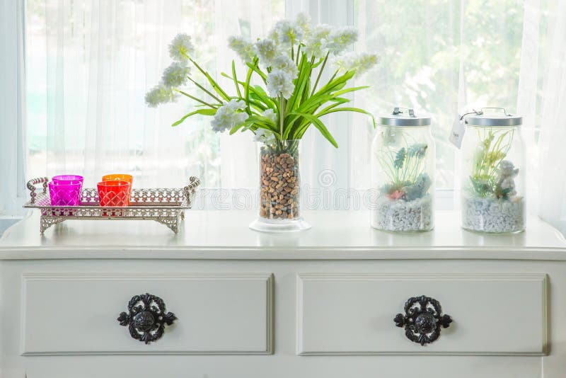 Vasen med blomman och tappning dekorerar på tabellen med fönsterbräda I royaltyfri foto Vasen med blomman och tappning dekorerar på tabellen med fönsterbräda I royaltyfri foto