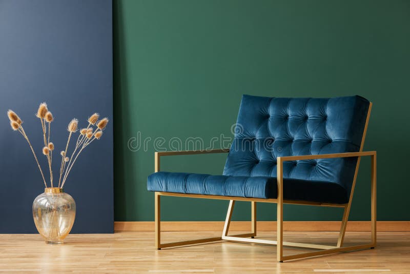 Vaso accanto alla poltrona nell'interno elegante blu e verde del salone Foto reale