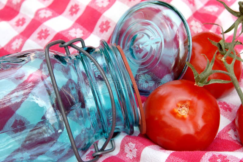 Vaso e pomodori d'inscatolamento dell'annata della nonna sulla vite