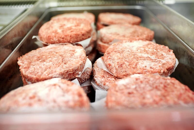 Vassoio del metallo di tortini congelati dell'hamburger immagine stock Vassoio del metallo di tortini congelati dell'hamburger immagine stock