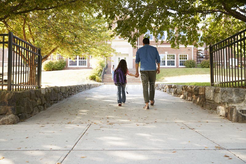 Vater Dropping Off Daughter in Front Of School Gates lizenzfreie stockfotos Vater Dropping Off Daughter in Front Of School Gates lizenzfreie stockfotos