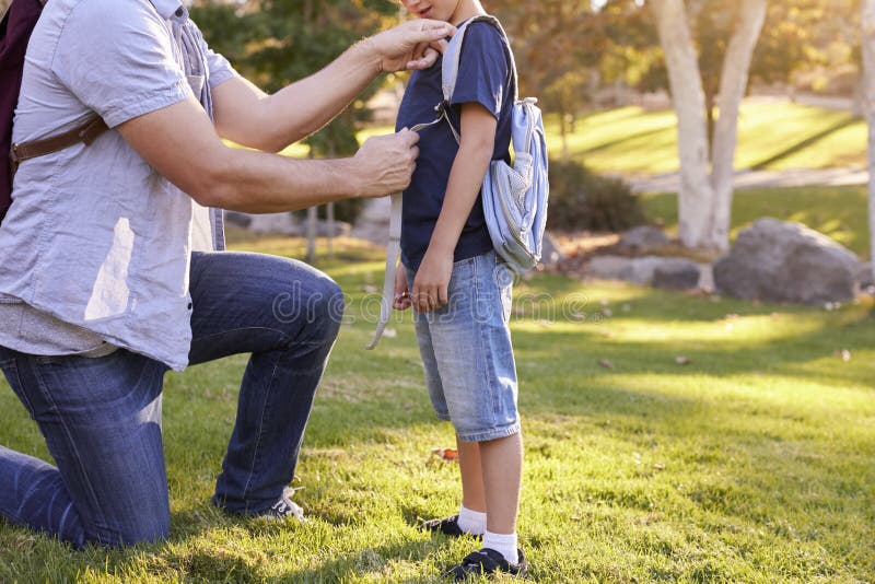 Vater-Fastening Son-` s Rucksack, wie sie zur Wanderung fertig werden lizenzfreie stockfotos Vater-Fastening Son-` s Rucksack, wie sie zur Wanderung fertig werden lizenzfreie stockfotos