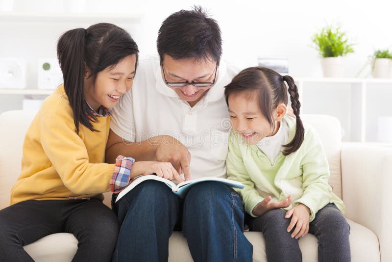 Vater las das Buch zu den Kindern stockbild Vater las das Buch zu den Kindern stockbild