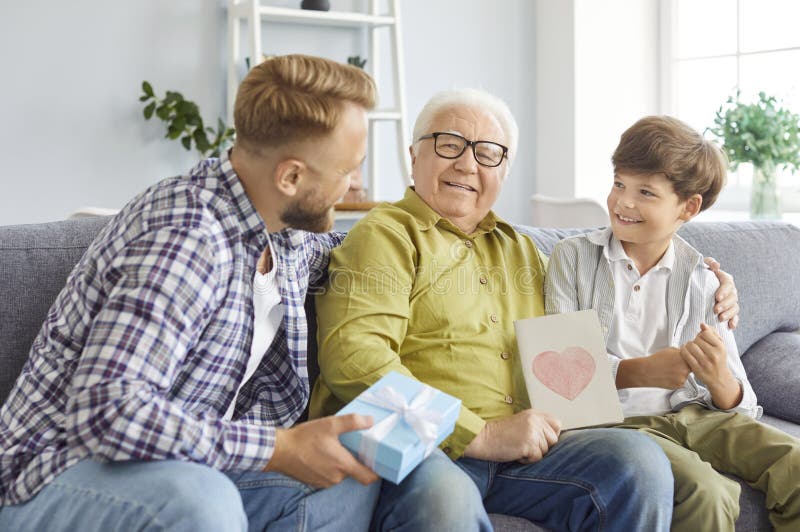 Vater mit Kind gratulieren zum Urlaub Senior Großvater sitzend auf Sofa zu Hause stockfoto