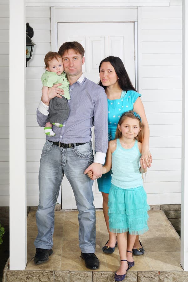 Vater, Mutter, Baby und Tochter stehen auf Portal des Hauses. lizenzfreie stockfotos Vater, Mutter, Baby und Tochter stehen auf Portal des Hauses. lizenzfreie stockfotos