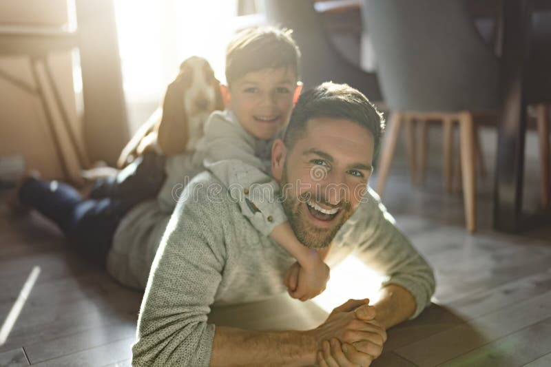 Vater oder Pate amüsieren sich zu Hause auf der Wohnfläche stockbilder