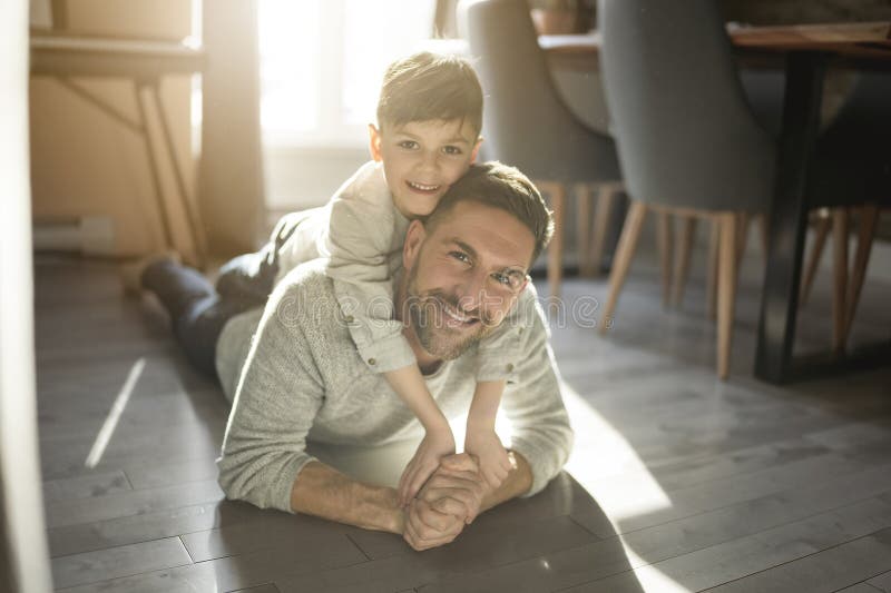Vater oder Pate amüsieren sich zu Hause auf der Wohnfläche lizenzfreies stockfoto