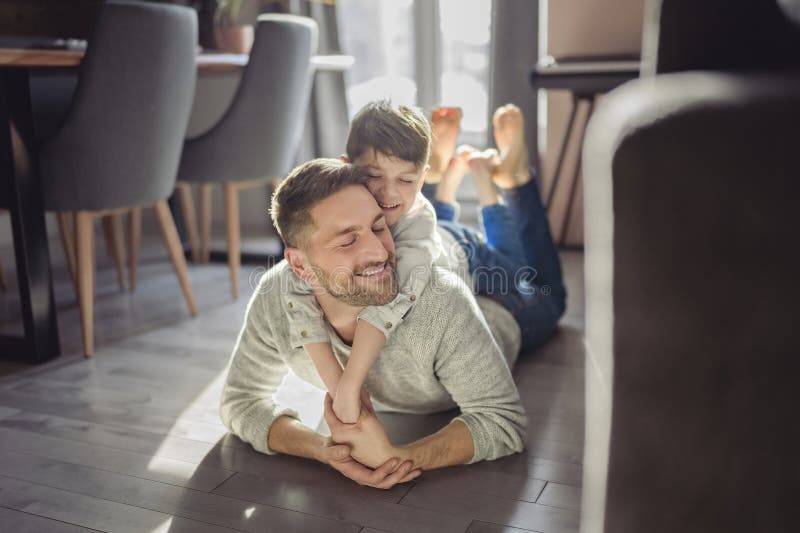 Vater oder Pate amüsieren sich zu Hause auf der Wohnfläche stockfotografie
