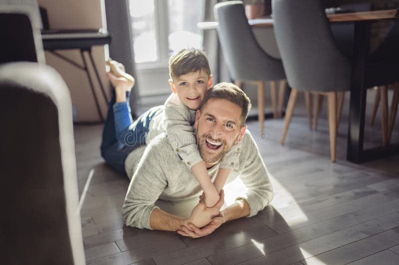 Vater oder Pate amüsieren sich zu Hause auf der Wohnfläche lizenzfreie stockbilder