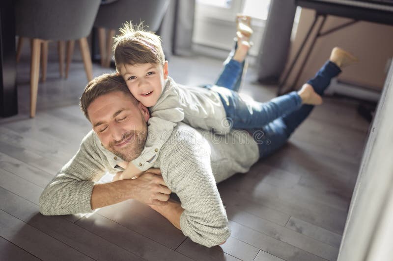Vater oder Pate amüsieren sich zu Hause auf der Wohnfläche stockbilder