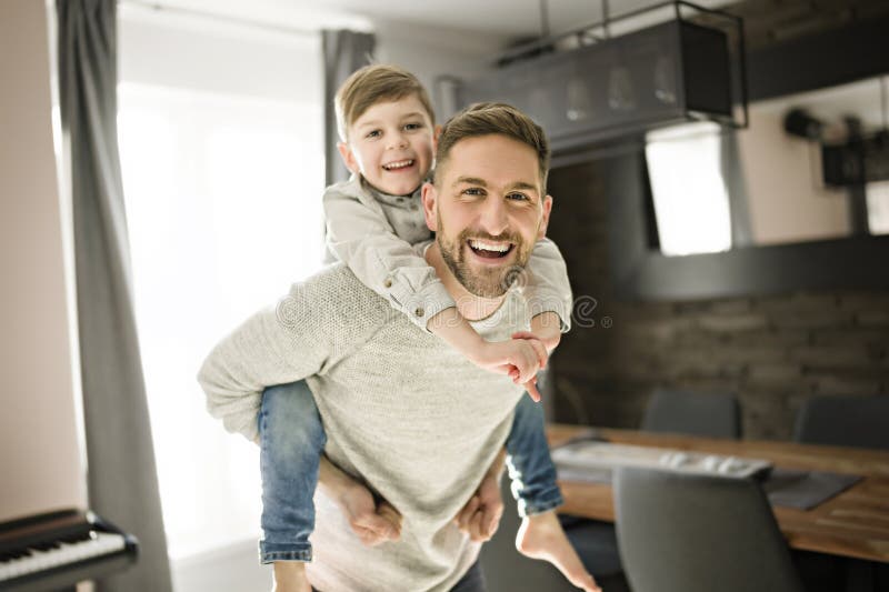 Vater oder Pate, der sich im Wohnzimmer auf seinem Rücken amüsiert lizenzfreie stockfotos