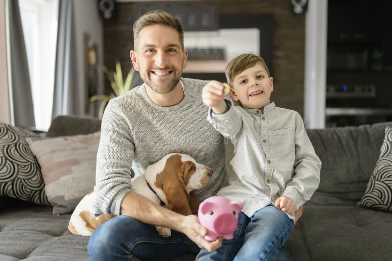 Vater oder Pate mit Basset Hund Spaß auf dem Wohnzimmer zu Hause pausen Geld auf Sparschwein lizenzfreie stockbilder