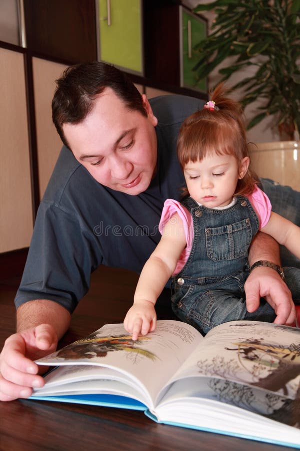 Vater und kleine Tochter liest Buch lizenzfreie stockfotos Vater und kleine Tochter liest Buch lizenzfreie stockfotos