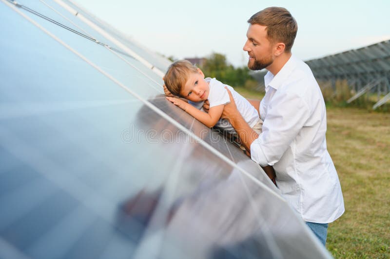 Vater und sein kleiner Sohn in der Nähe von Solarzellen.