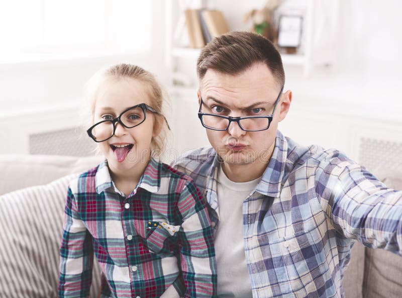 Vater und seine kleine Tochter, die lustiges selfie nehmen lizenzfreies stockfoto Vater und seine kleine Tochter, die lustiges selfie nehmen lizenzfreies stockfoto