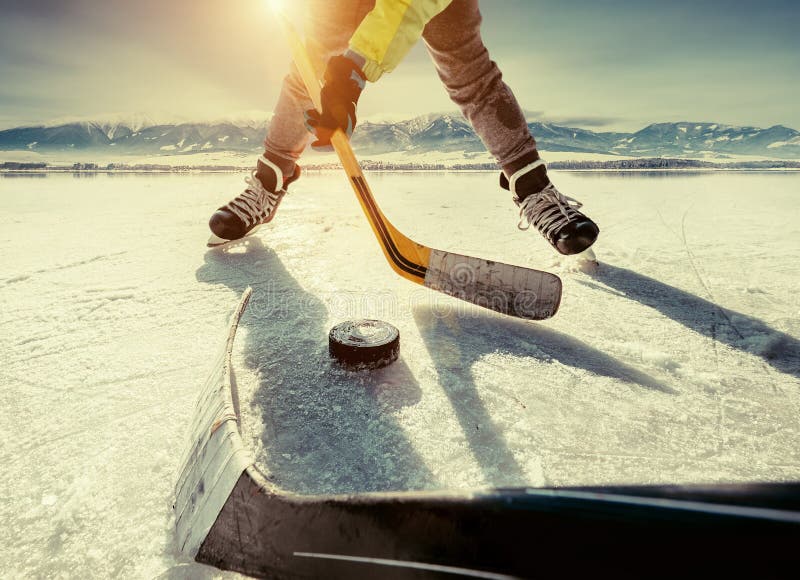Vater und Sohn, die das Hockey auf dem gefrorenen hoher Gebirgsla spielen lizenzfreie stockfotografie Vater und Sohn, die das Hockey auf dem gefrorenen hoher Gebirgsla spielen lizenzfreie stockfotografie