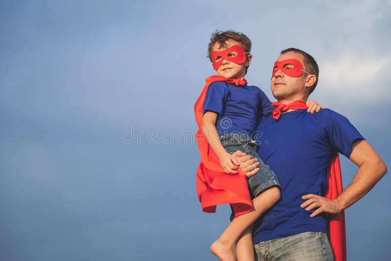 Vater und Sohn, die draußen Superhelden zur Tageszeit spielen stockfoto Vater und Sohn, die draußen Superhelden zur Tageszeit spielen stockfoto