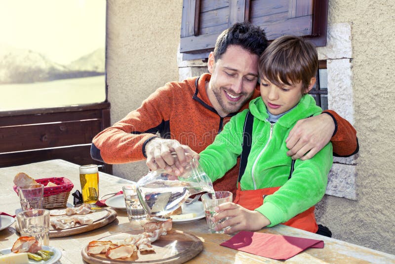 Vater und Sohn, die in einem Chalet zu Mittag essen stockfotos Vater und Sohn, die in einem Chalet zu Mittag essen stockfotos