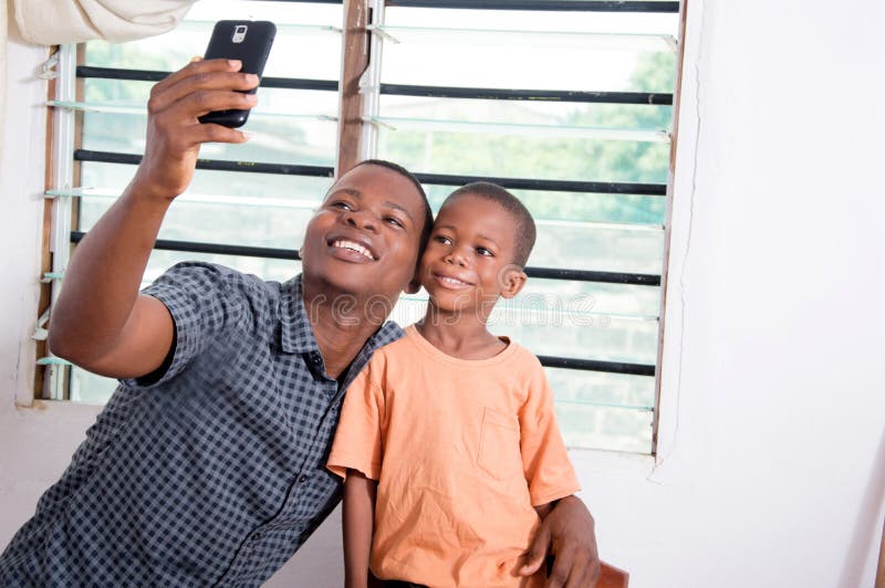 Vater und Sohn, die Fotos mit seinem Telefon machen stockbild Vater und Sohn, die Fotos mit seinem Telefon machen stockbild