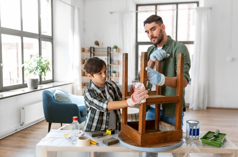 renovation, diy and home improvement concept - father and son degreasing old round wooden table surface with tissue. renovation, diy and home improvement concept - father and son degreasing old round wooden table surface with tissue