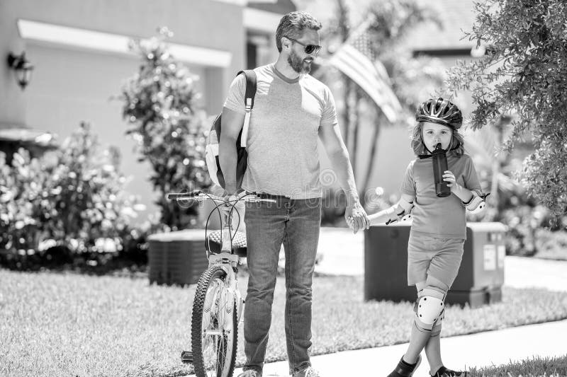 Vater- und Sohn-Team in der Kindheit. Vater und Sohn mit Kindheit zusammen. Vater und Sohn, die ein Fahrrad-Kind teilen. Vater stockfoto
