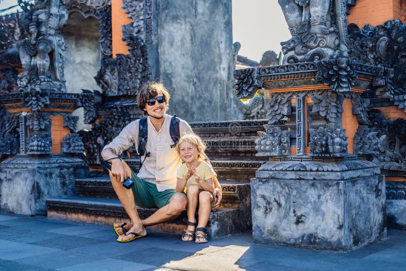 Vater- und Sohntouristen auf dem Hintergrund von Tanah-Los - Tempel lizenzfreies stockfoto Vater- und Sohntouristen auf dem Hintergrund von Tanah-Los - Tempel lizenzfreies stockfoto