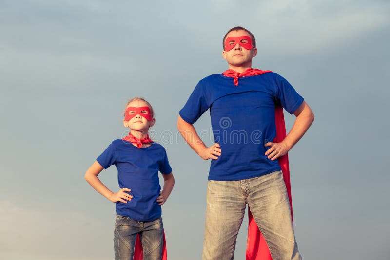 Vater und Tochter, die Superhelden zur Tageszeit spielen lizenzfreies stockfoto Vater und Tochter, die Superhelden zur Tageszeit spielen lizenzfreies stockfoto