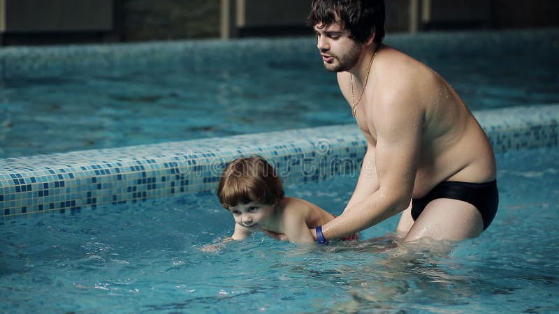 Vater unterrichtet Sohn, im Pool zu schwimmen