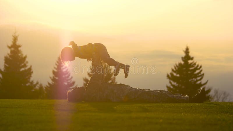 Vatisoldat, der auf dem Gras liegt und wenig Tochter umarmt