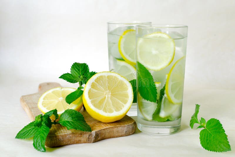 Vatten för detox för citronmintkaramell Hemlagad lemonad med mintkaramellen, citronen och is i exponeringsglas Träbräde, skivad c arkivfoton Vatten för detox för citronmintkaramell Hemlagad lemonad med mintkaramellen, citronen och is i exponeringsglas Träbräde, skivad c arkivfoton