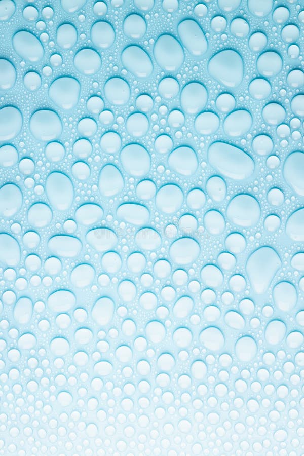 Vattendroppar på mjuk ljusblå akvblåbakgrund som färsk kallfärgad textur av skintvätt från olika former droppar med övertoning