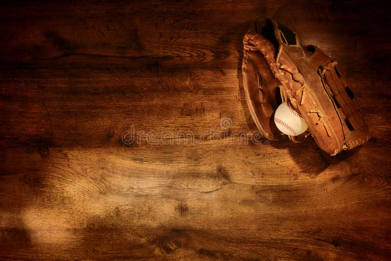 Vecchi guanto e sfera di baseball su priorità bassa di legno
