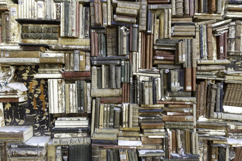 Old books piled on a wall, stacked in a disorderly fashion, antique bookcase full of old books great as a background. Old books piled on a wall, stacked in a disorderly fashion, antique bookcase full of old books great as a background
