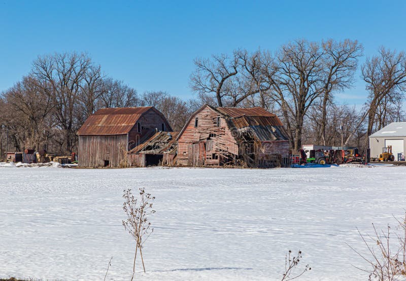 Vecchia bellezza, un fienile in rovina, catturato in inverno. Una bellezza in difficoltà. fienile dilapidato in una fattoria di nebraska rurale, catturato alla fine dell'inverno con pavimenti coperti di neve e cielo azzurro. concetto di vecchiaia in background fine vita fine vita ecc..