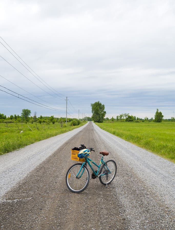 Old recreational bike in the middle of a gravel road demonstrating adventure and exploration. Old recreational bike in the middle of a gravel road demonstrating adventure and exploration